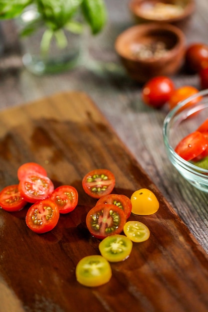 Slicing heirloom cherry tomatoes on wood cutting board.