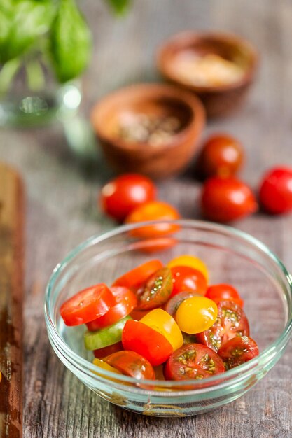 Slicing heirloom cherry tomatoes on wood cutting board.