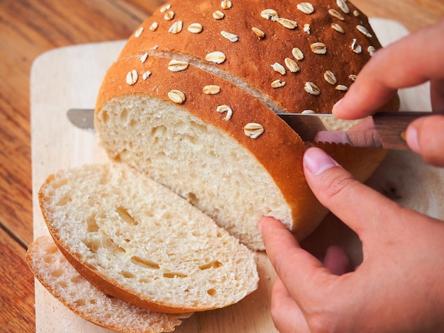 Slicing homemade bread by knife.