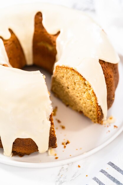 Slicing homemade eggnog bundt cake with an eggnog glaze