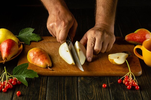 Фото Нарезка зрелых груш ножом в руках шеф-повара для десерта вкусная концепция диеты груши