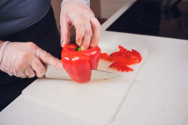 Slicing sweet red pepper on cutting board