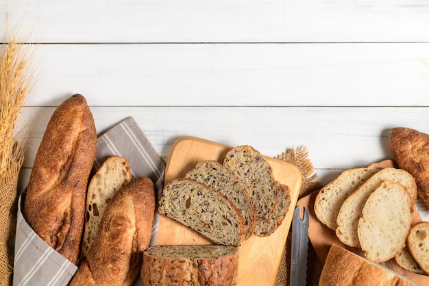 Slide multi grain sourdough bread and sliced Baguette on white wood