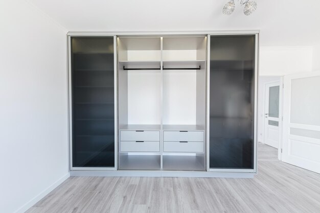 Sliding door wardrobe with open glass doors in the room