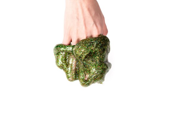 Slijm maken proces. Groen glitter slijm in de hand geïsoleerd op wit