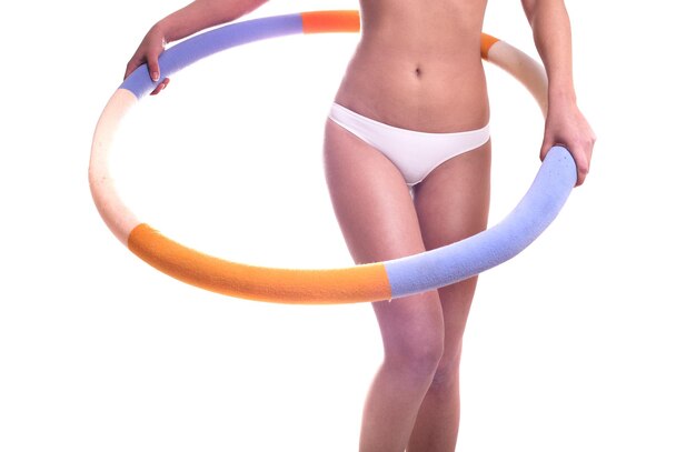 Slim beautiful healthy young body of white skin woman with hula hoop