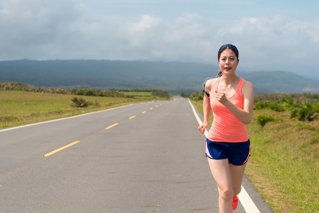 slim beautiful woman every morning sporting to running on a clean road listen to music training the body efforts to maintain the body with copyspace spectacular background.
