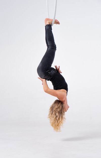 Slim and flexible Girl In An aerial hoop isolated On A White Background.