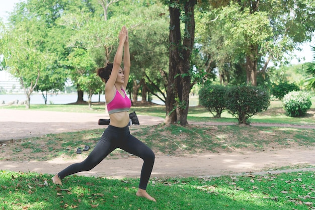 Slim girl play yoga on the lawn at the parkrelax in nutureAsian Girls love health practicing yoga