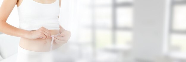 Slim healthy woman holding measuring tape