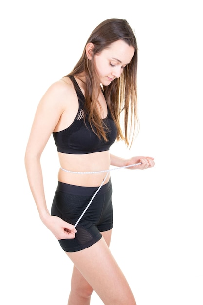 Slim and healthy woman measuring waist with a tape