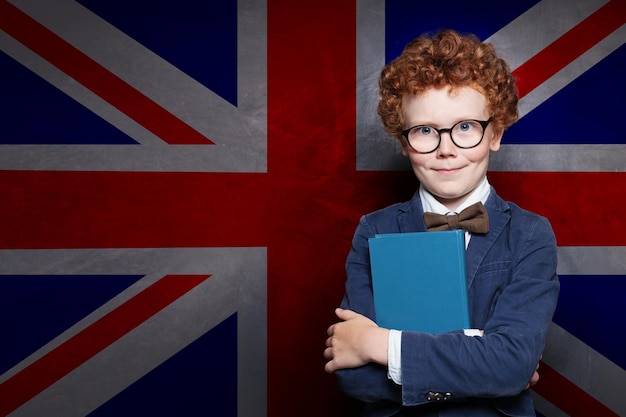 Slim kind met boek op de achtergrond van de Britse vlag.