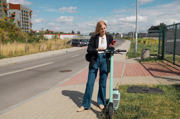 Slim openbaar vervoer gelukkige jonge vrouw huurt een elektrische scooter die milieuvriendelijk vervoer ontgrendelt