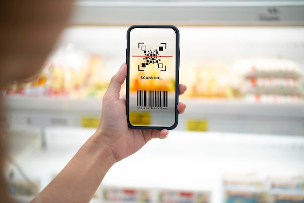 Slim retailconcept vrouwelijke handen met behulp van barcodescan voor informatie over het product in de supermarkt