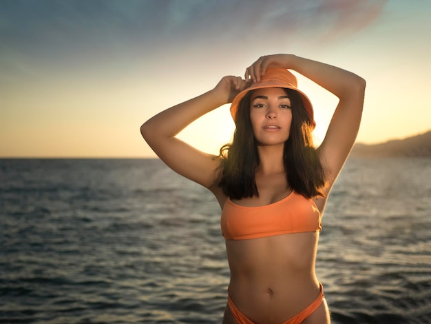 Slim woman in bikini standing near sea