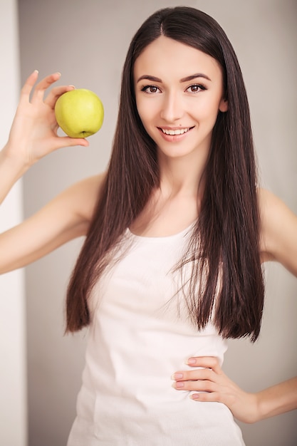 スリムな女性は手に緑のリンゴを保持します。