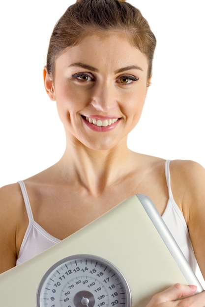 Slim woman holding weighing scales