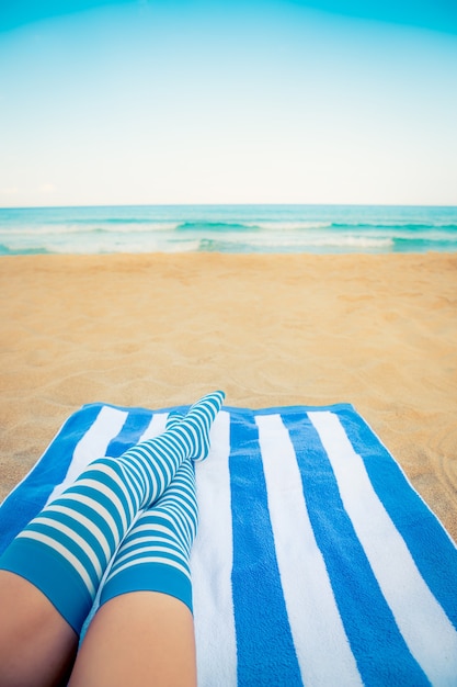 Slim woman legs on a beach Summer vacation and travel concept