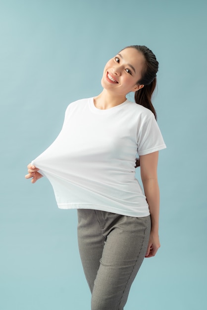 Slim woman in oversized t-shirt on color background. Weight loss