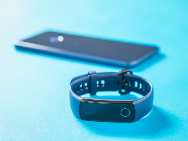 Slimme armband en smartphone op een blauw oppervlak