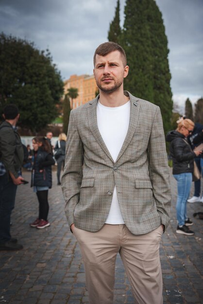 Slimme casual man in geruite blazer die buiten staat Europese stad vibe