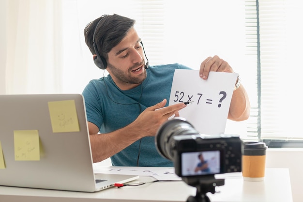 Slimme jonge blanke zakenman student, leraar tutor draag headset, kijk naar de camera, praat begroeting bij video-opnamen. Technologie leert lesgeven in online chat, afstand in onderwijsconcept.