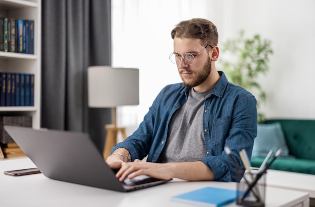 Slimme jonge man zit aan bureau