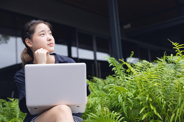 Slimme Oost-Aziatische jonge zakenvrouwen van de nieuwe generatie denken projecten creatief buiten met laptopcomputer