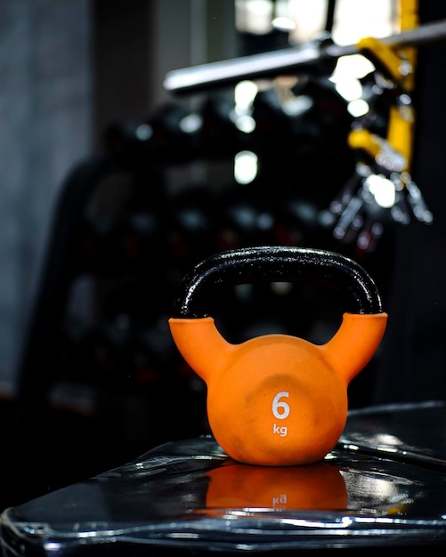 Foto slimme oranje kettlebell tegen donkere gym achtergrond krachttraining essentials