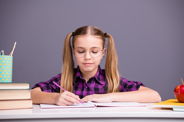 Slimme schoolmeisje huiswerk aan de balie