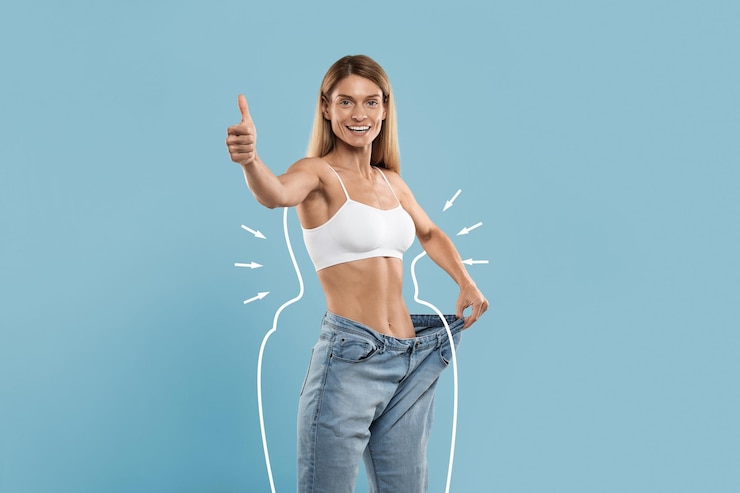 Photo slimming result happy slim female in oversized jeans showing thumb up