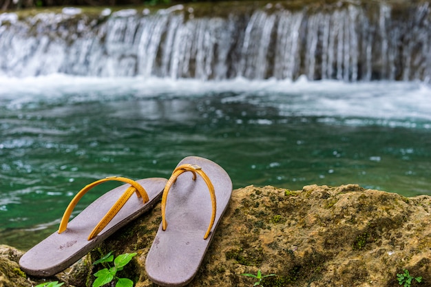 Slippers werden op de rots in de waterval geplaatst