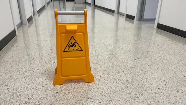 Slippery sign on wet floor in office building