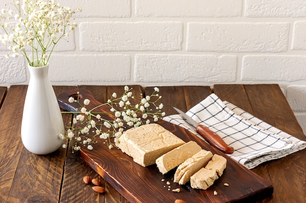 Slised sunfower halva dessert op een houten bord op een tafel. Zoet oosters dessert van noten en zaden.