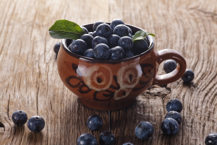 Фотография sloes в миску на деревянный стол