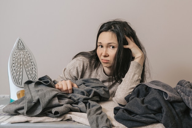 Ragazza sciatta con molti vestiti da stirare