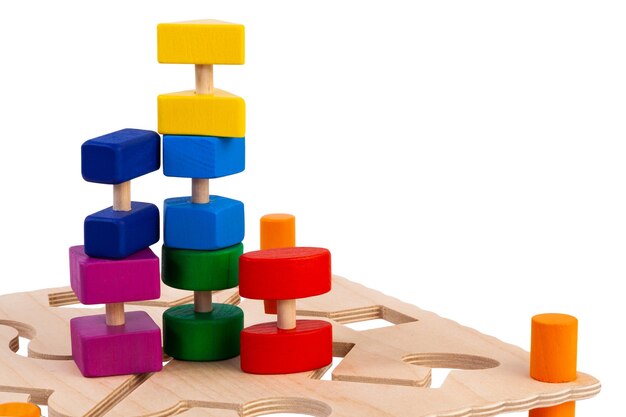 Sloseup of a labyrinth with multicolored puzzles on a wooden busy board educational toy for children babies on a white isolated background A toy for entertaining children and resting parents