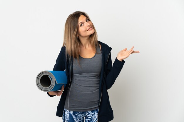 Slovak girl going to yoga classes isolated on white background extending hands to the side for inviting to come