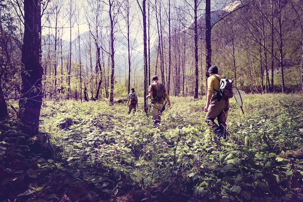 슬로베니아, Bovec, 세 명의 낚시꾼이 Soca 강을 향해 숲을 걷고 있습니다.
