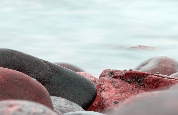 Slow shutter speed photographing water surrounding rock formation in Namibia, Africa at sunset in the Atlantic Ocean