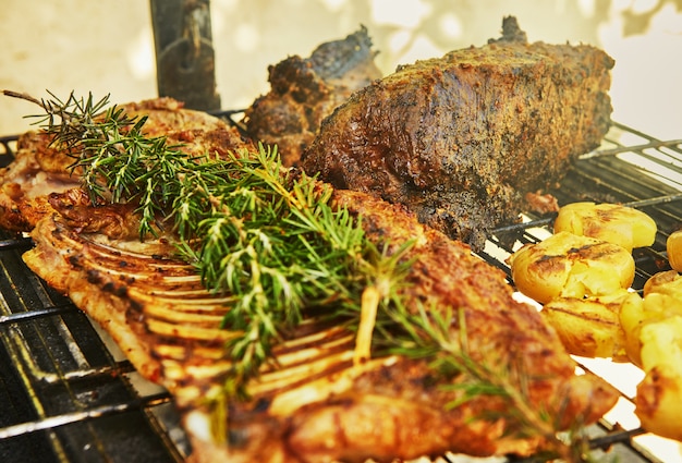 Slow-smoked lamb ribs on the grill with rosmarine