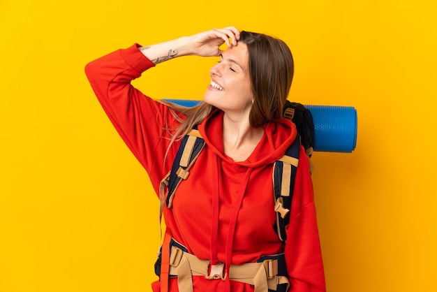 Slowaakse bergbeklimmer vrouw met een grote rugzak geïsoleerd op gele achtergrond veel glimlachen