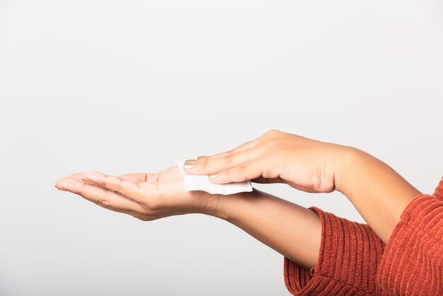 Sluit de hand van een Aziatische vrouw die ze met natte papieren zakdoekjes haar handen schoonmaakt