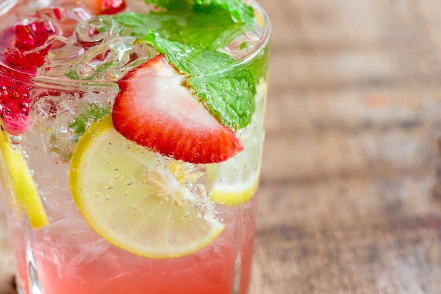 Sluit de kalkmojito van de aardbeicitroen in duidelijk glas op rustieke houten lijst in de zomerdrank