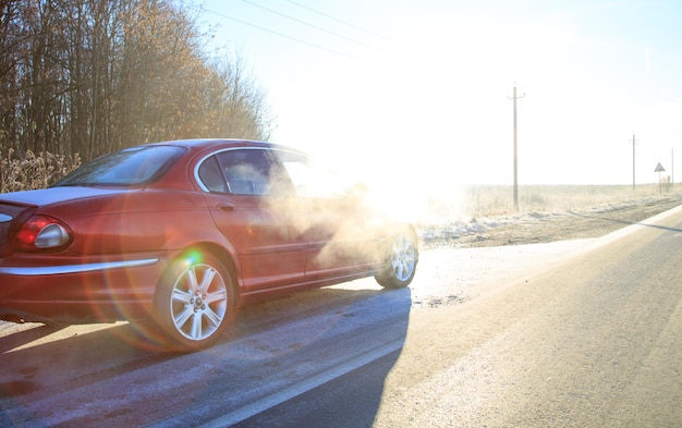 Sluit de voorkant van de nieuwe rode auto op de asfaltweg op een zonnige dag