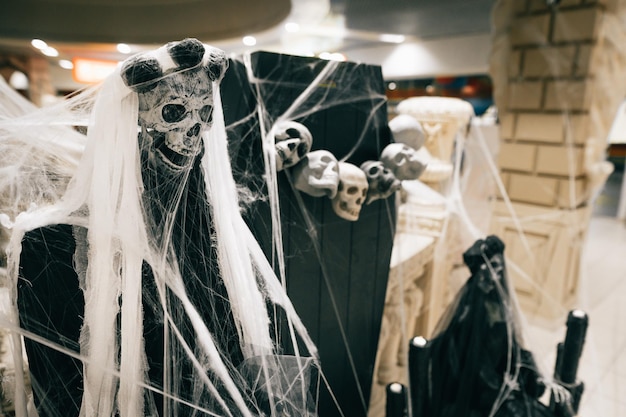 Sluit foto vrouw skelet in zwarte kleding en spinnenweb binnenshuis tijdens Halloween