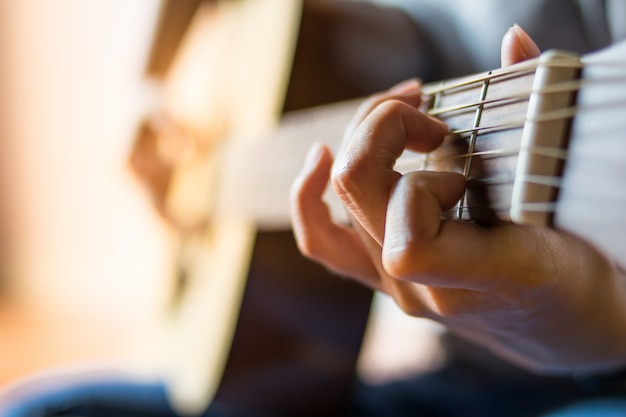 Sluit handmeisje omhoog speelend de gitaar