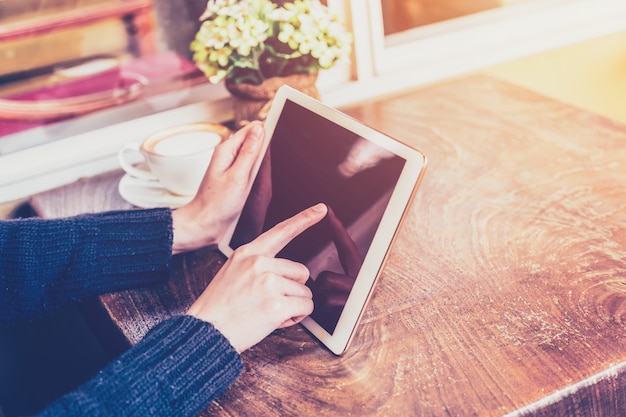 Sluit handvrouw omhoog gebruikend tablet in koffiewinkel met uitstekende toon.