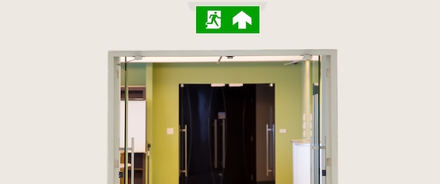 Sluit het groene nooduitgangbord met de deuruitgang.