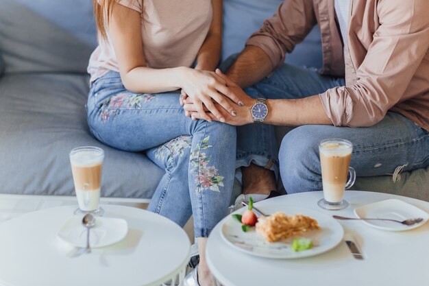 Sluit omhoog beeld van het houden van van paar die op het terras van het de zomerkoffie ontspannen.